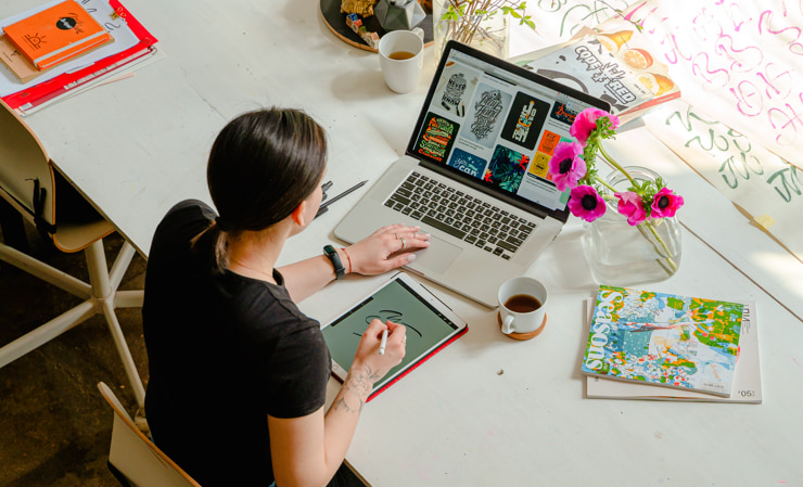 Graphic designer at work with her Mac and iPad.